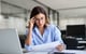 woman sitting at desk reviewing paperwork