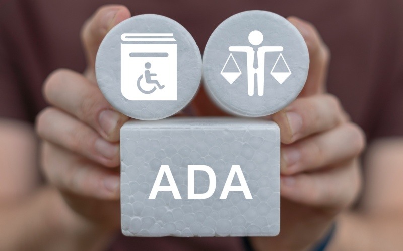 Man holding white blocks with ADA and related icons