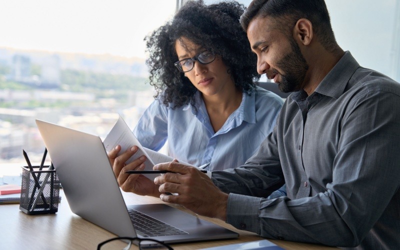 man and woman sitting together working on computer