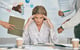 stressed out working woman holding her hands to her head