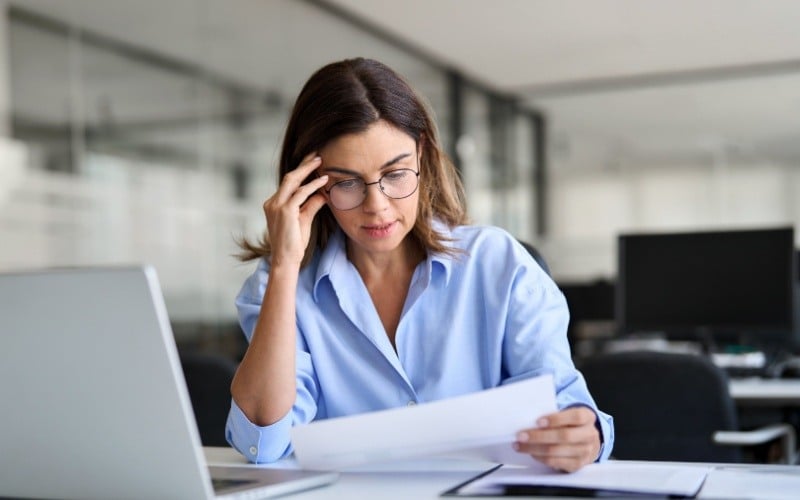 woman sitting at desk reviewing paperwork