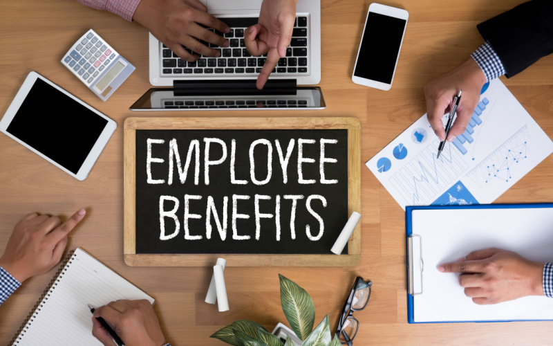 employee benefits written on desk with person working