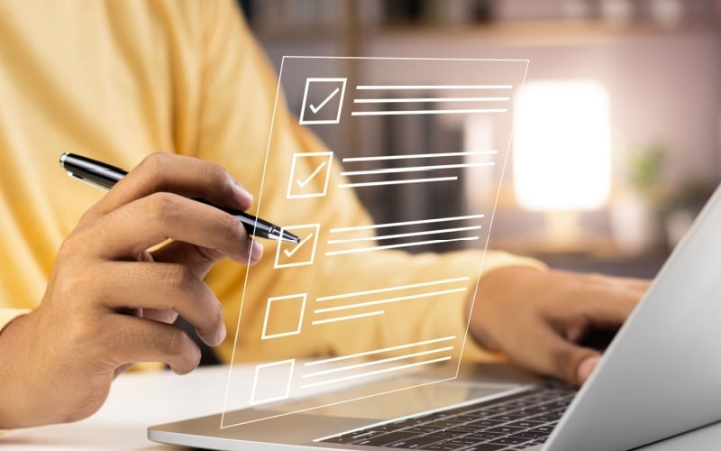 person on computer completing checklist