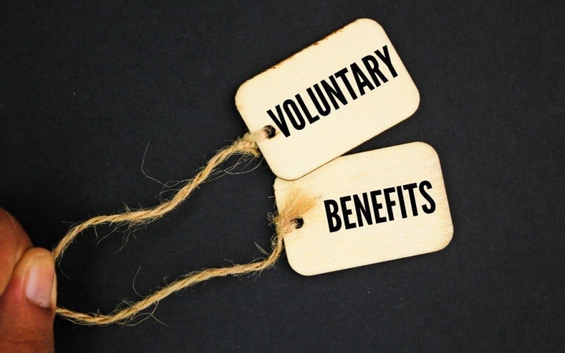 words voluntary benefits written on paper tags