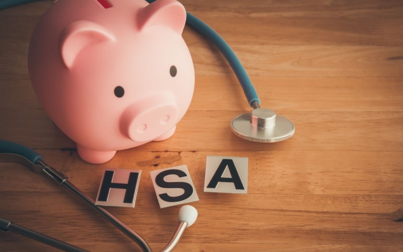 piggy bank, stethoscope, and card that reads HSA