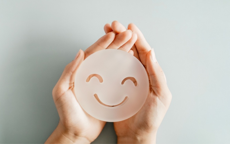 person holding happy face mask