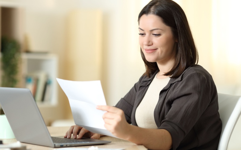 woman sitting at desk reading paperwork