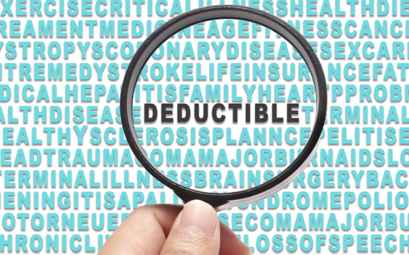 hand holding magnifying glass over the word deductible