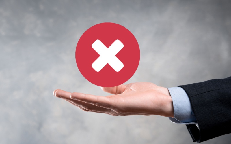 hand holding a circle with a big X