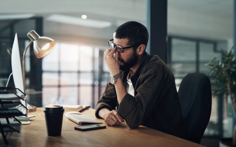 man sitting at desk looking stressed