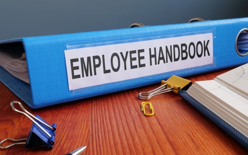 employee handbook binder sitting on desk