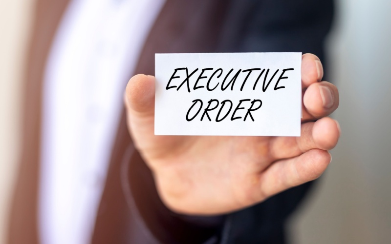 man holding business card that reads executive order