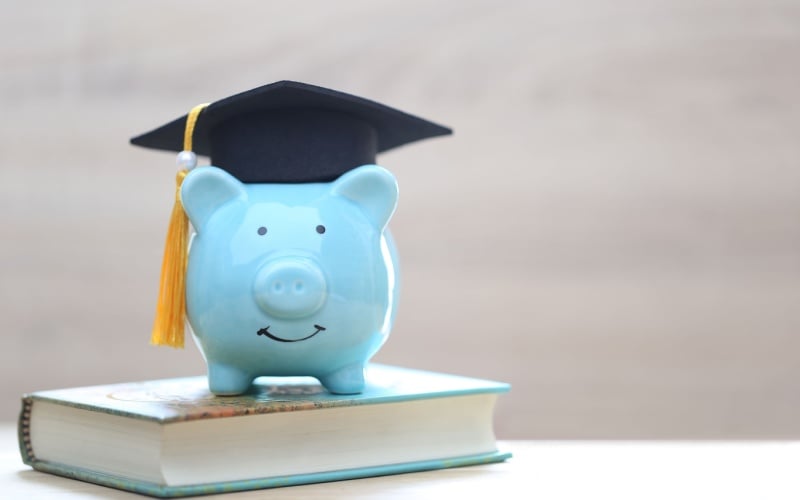 piggy bank with graduation hat, sitting on book
