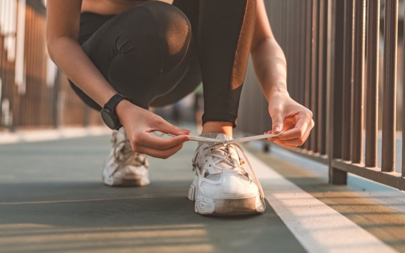 woman bending down to tie shoes