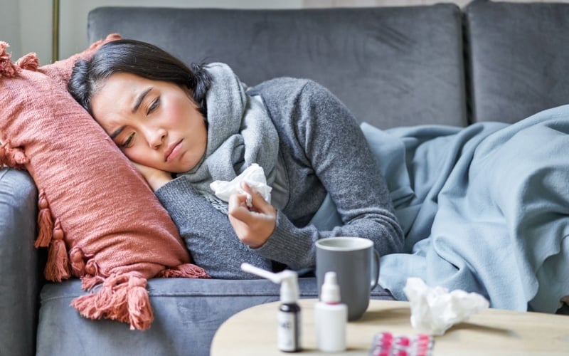 woman sick laying on couch