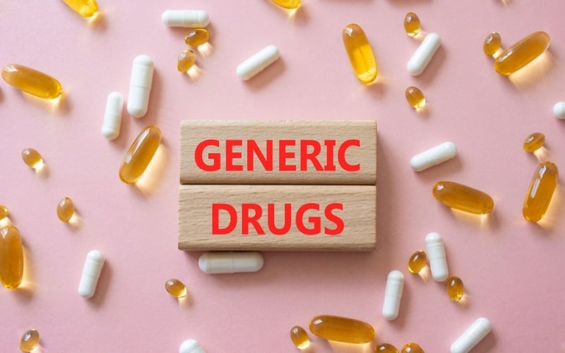 generic drugs written on wood blocks with pills in background