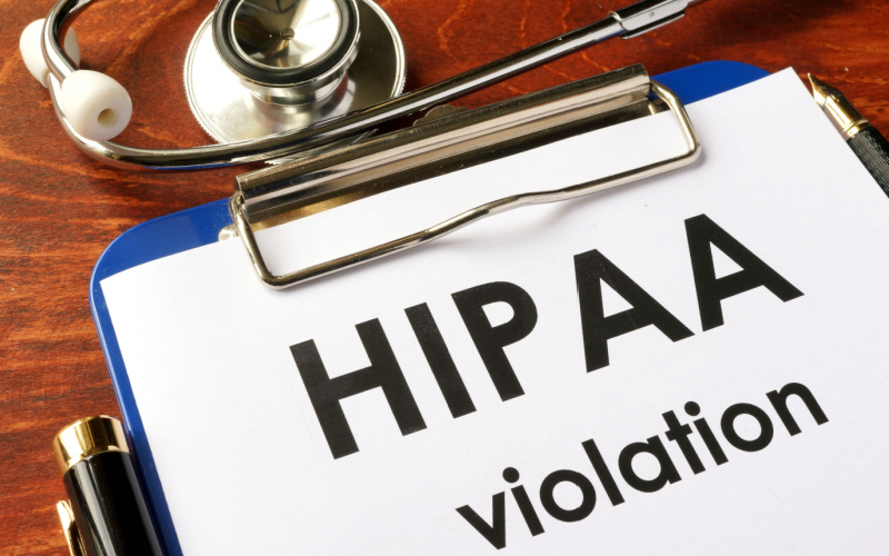 HIPAA violation written on clipboard
