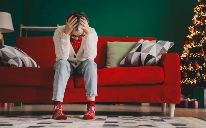 person on couch with head in their hands