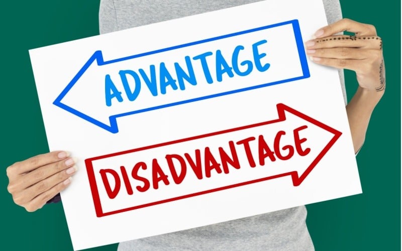 woman holding up sign with two arrows that read advantage and disadvantage