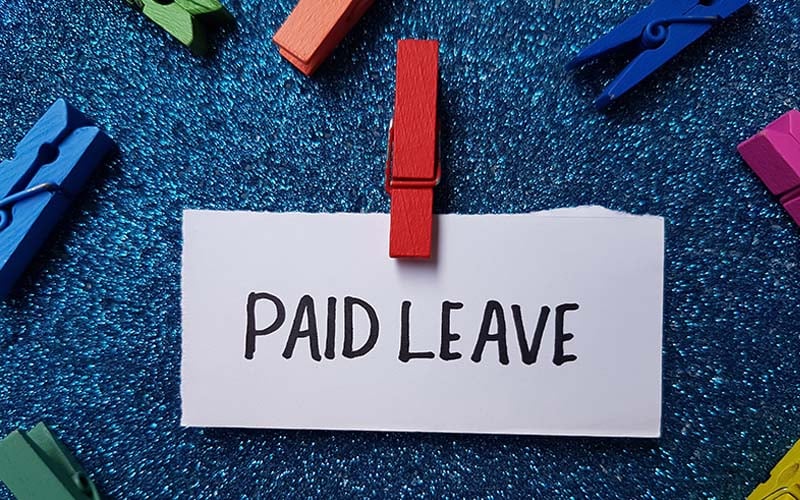 paid leave written on notecard attached to red clothespin