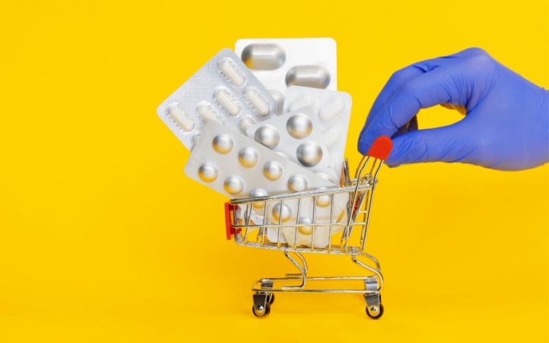 hand pushing shopping cart with medication