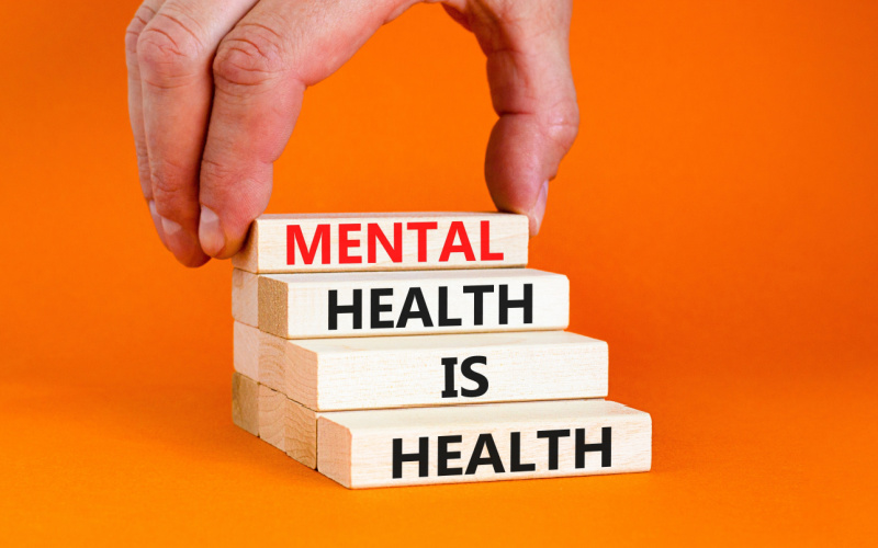 hand on top of building blocks that read mental health is health