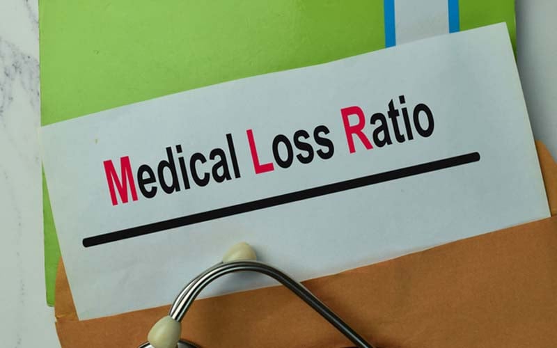 medical loss ratio written on sheet of paper on top of  notebook
