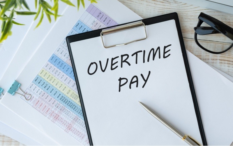 the words overtime pay written on a clipboard
