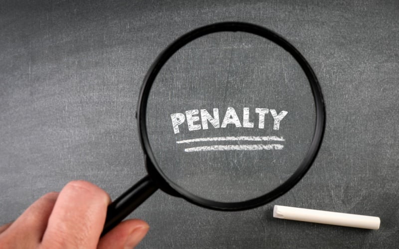 PENALTY. Text, magnifying glass and white chalk on a blackboard