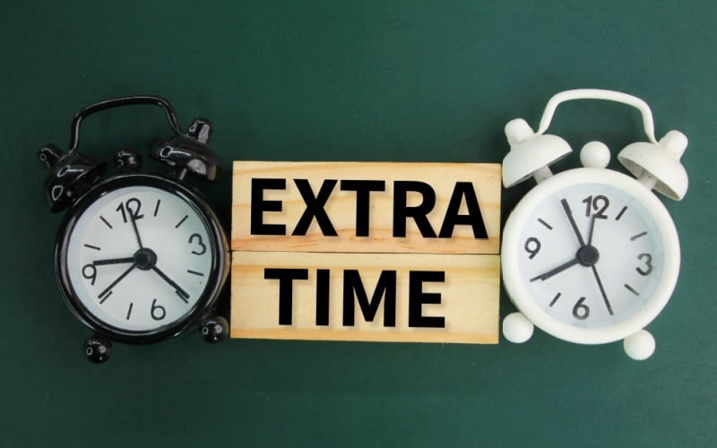 2 alarm clocks with sign that reads extra time