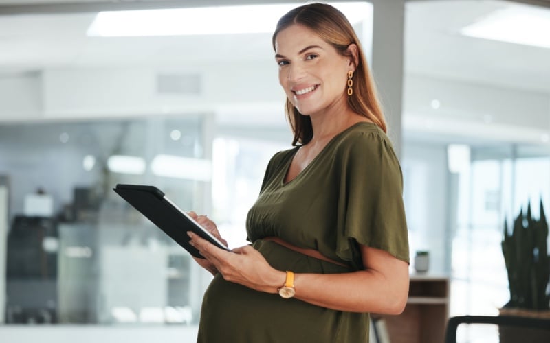 pregnant lady working and holding ipad