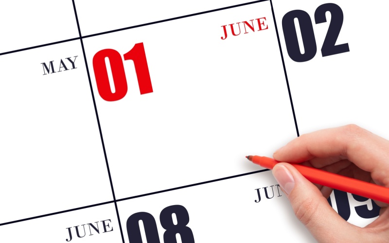 hand with red pen on June 1 date