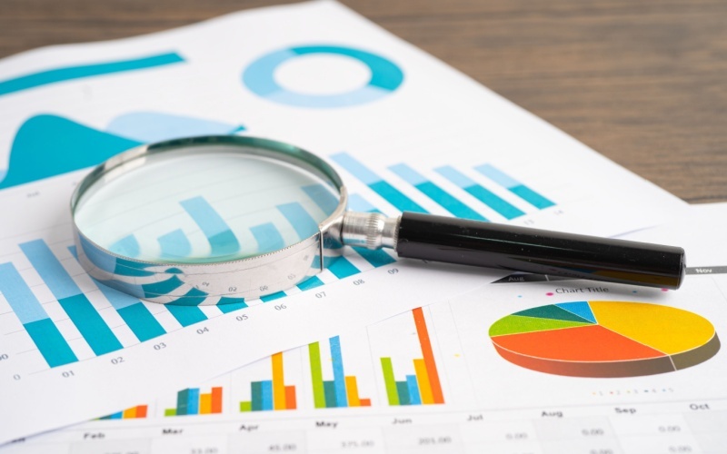 magnifying glass sitting on top of reports