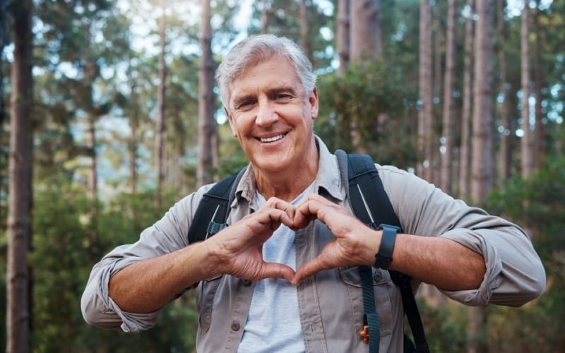 man hiking and making heart shape with his hands