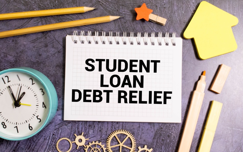 student loan debt relief written in notebook sitting on desk