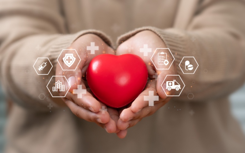 person holding stress ball heart with medical icons surrounding