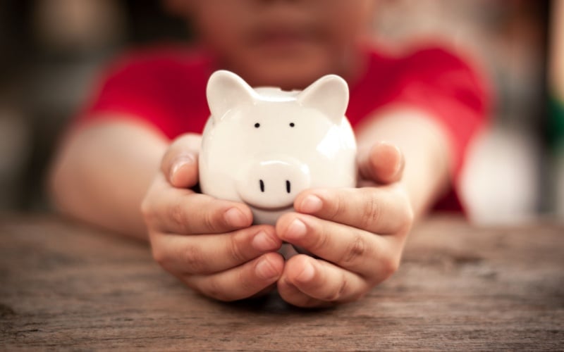 child holding piggy bank